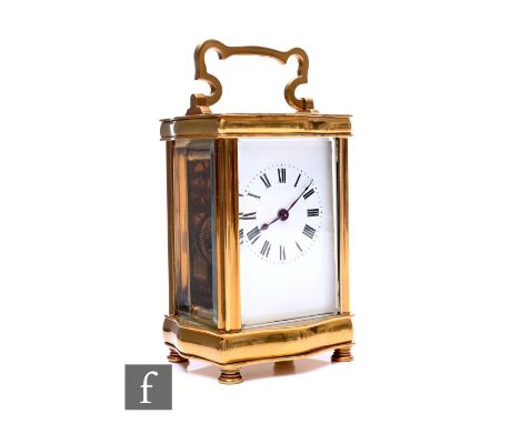 An early 20th Century brass carriage clock of cartouche shape with white enamelled dial, key present.
