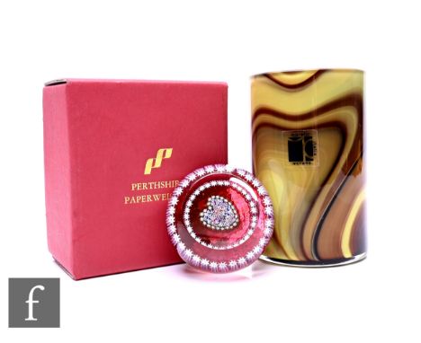 A late 20th Century Perthshire glass paperweight with millefiori heart design on pink ground with polished top window, retain