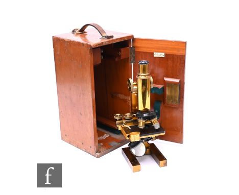 A late 19th Century brass microscope by Ross London No 8437, with single monocular lens above a scale, the case fitted with t