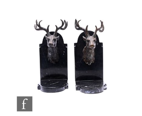 A pair of late 20th Century bronze book ends in the form of stag's heads on mounted black veined marble stands, height 23cm. 
