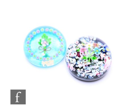 A contemporary William Manson glass paperweight of domed form internally decorated with a central spray of stylised flowers i