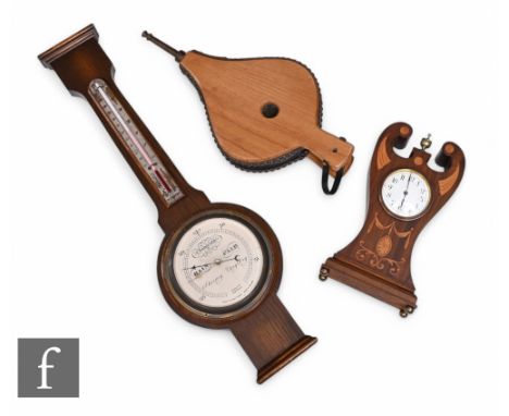 An Edwardian Art Nouveau style inlaid mahogany lyre shaped mantle clock, circular white dial, decorated with swags and fan pa