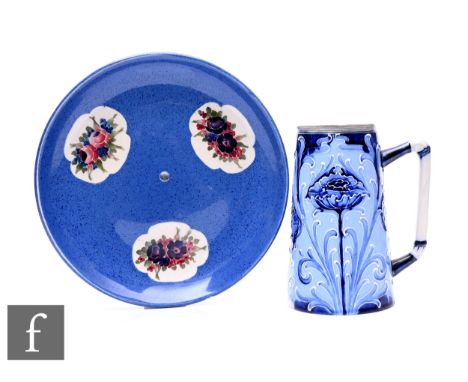 William Moorcroft for Moorcroft Pottery, a powder blue cakestand platter (drilled), with three quatrefoil floral panels, diam