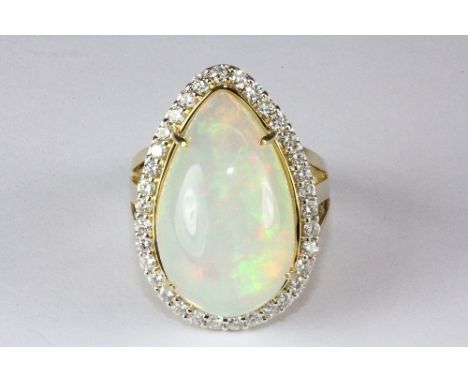 A magnificent 18ct yellow gold ring set with a large opal (approx. 12.3ct) surrounded by (approx 1ct) diamonds (P).