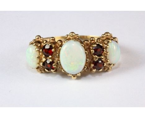 A 9ct yellow gold, opal and garnet ring, (U).