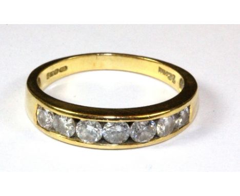 An 18ct gold ring, channel set with 9 brilliant cut diamonds, (O.5).