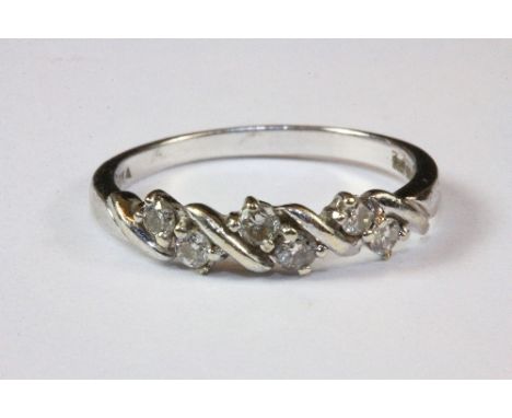 A 9ct white gold diamond set fancy half eternity ring, (O).