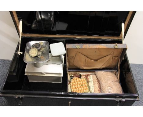 A vintage black painted tin trunk and contents