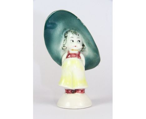 A 1930s figure of a little girl wearing a large hat (probably Hummel), H. 10cm.