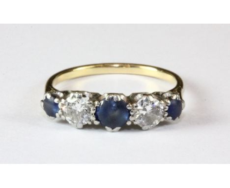 A yellow metal (tested high carat gold) ring set with 2 brilliant cut diamonds and 3 sapphires (N).