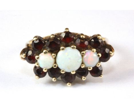 A 9ct yellow gold garnet and opal ring, (L).