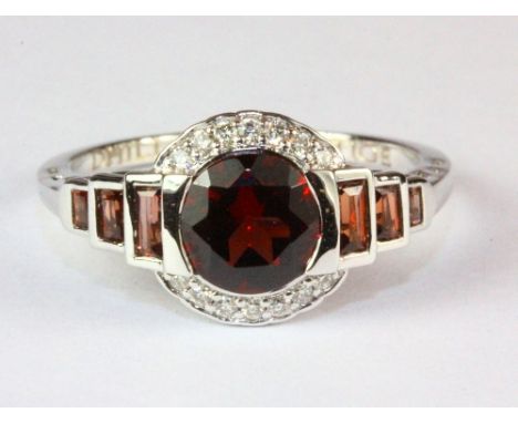 A 9ct white gold garnet and diamond cluster ring, (M).