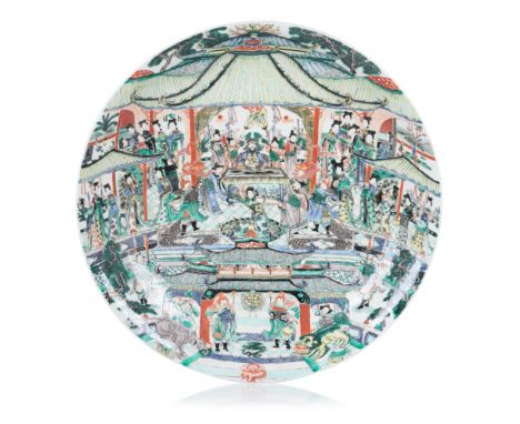 A large plate Chinese porcelainDecorated in Famille Verte enamels, depicting a court scene in a palatial courtyard, featuring