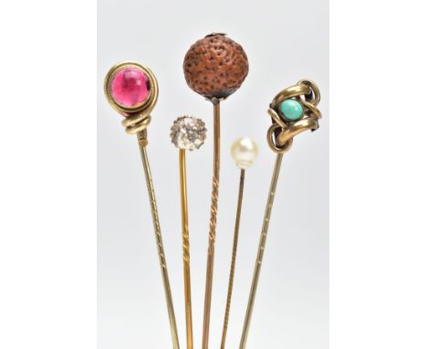 FIVE EARLY 20TH CENTURY STICK PINS, to include a circular nut pin, a red paste set pin, a colourless paste set pin, a yellow 