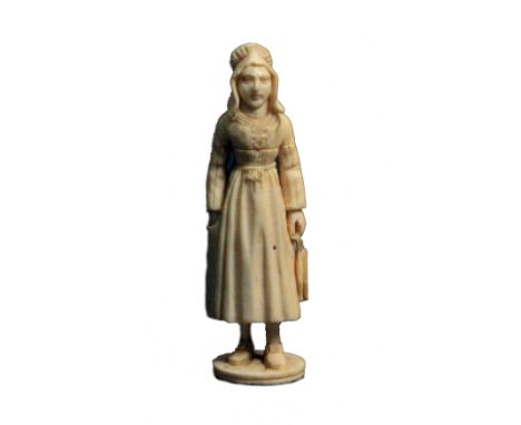 A 19th Century carved Dieppe ivory standing needle case, as a fisher woman in traditional costume, one hand in her pocket the