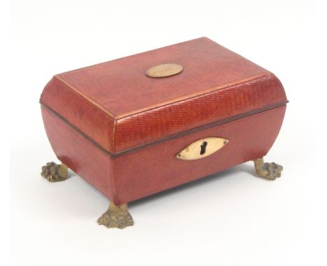 A Regency red leather sewing box for a child, of sarcophagal form with oval gilt escutcheon and lid plaque, raised on four li