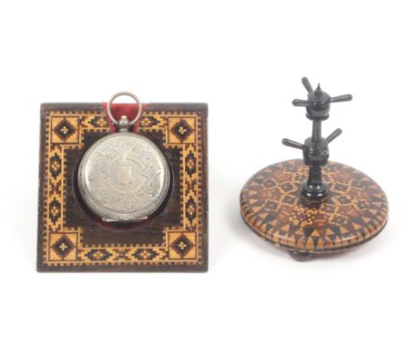 A Tunbridge ware watch stand and a ring stand, the first of angled form with a border of geometric mosaic, with a watch and k