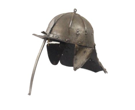 A Zischagge or lobster tailed helmet, probably 17th Century, the skull with radiating ribs to a star and ring finial, shaped 