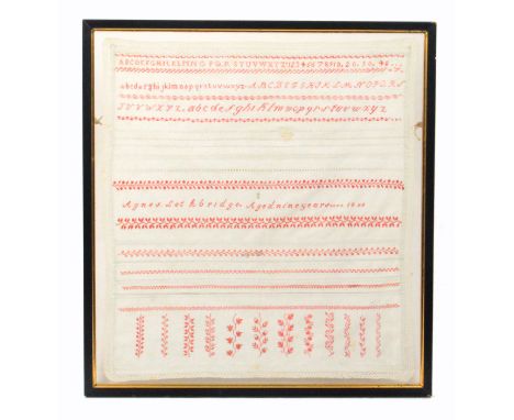 A band sampler 'Agnes Lethbridge, Aged Nine Years É. 1850', in red and white with bands of alphabets and numerals, cut work a