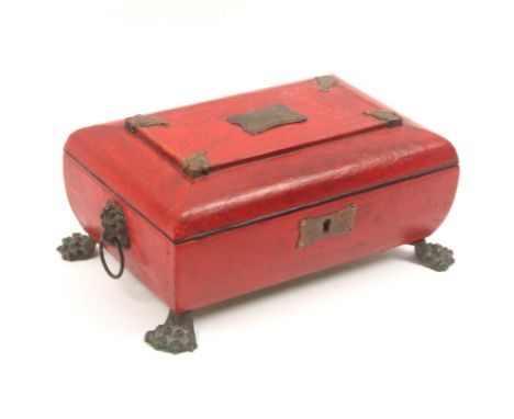 A Regency red leather sewing box of bombe form, raised on brass lion paw feet with brass lion mask ring handles, gilt brass e