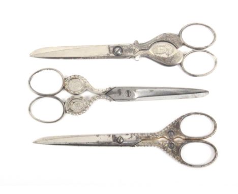 Three pairs of larger format steel scissors  comprising two pairs with portrait medallions, the first stamped 'AN' and with p