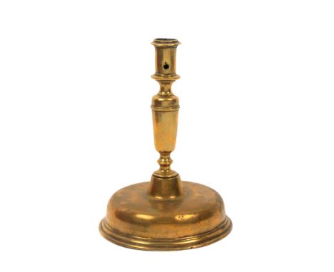 A 17th Century brass candlestick probably Spanish, on a domed base, 22cm high, 16cm dia. at base.                            
