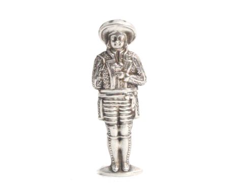 A continental figural silver needle case, in the form of a male in breaches, decorated jacket and hat, a group of playing car