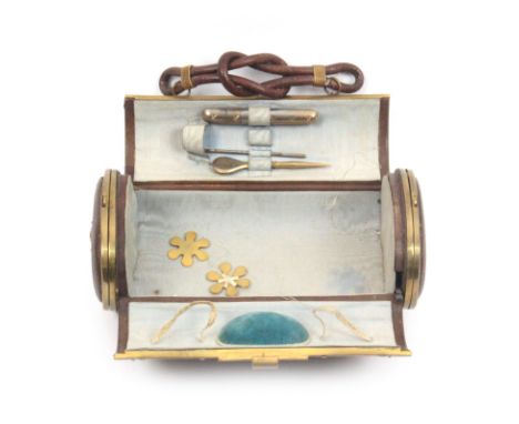 A continental sewing companion, circa 1880, of oval section in brown leather with engraved gilt metal mounts with looped carr