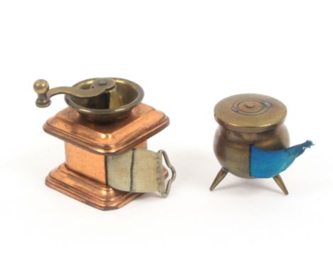 Two novelty tape measures, comprising a brass cauldron, complete tape in inches and centimetres marked 'London. Made in Austr