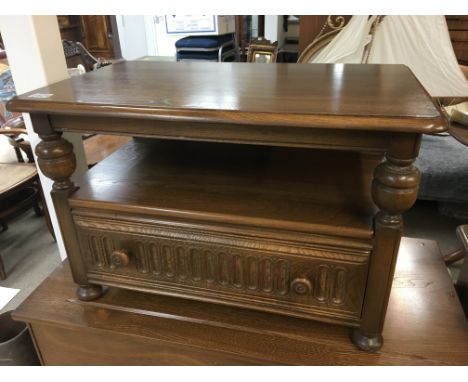 An Ercol side table the top with a twin flap top above open shelf and drawer. Very good condition few scratches to the top.74