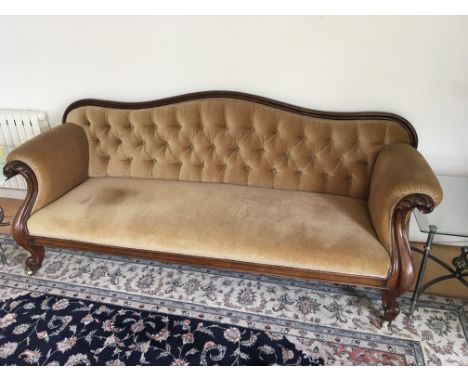 A large Victorian walnut sofa with button back upholstery and carved and scroll walnut ends length 205cm long.