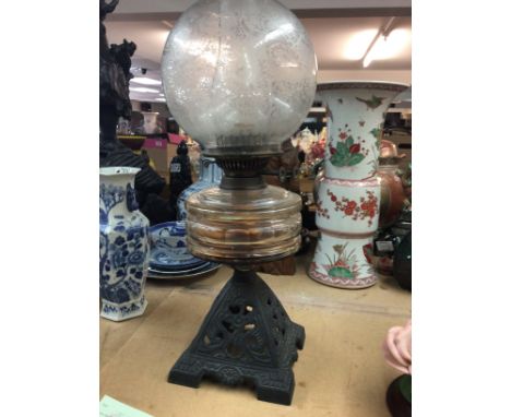 A oil lamp with engraved shade on cast iron base . NO RESERVE