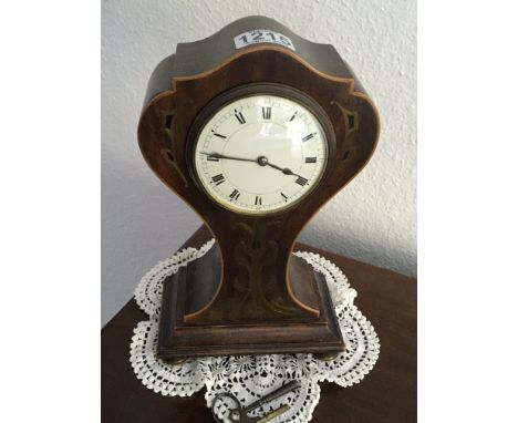 An Art Nouveau influence inlaid mantel clock. Inlaid decoration and with a white enamel dial.