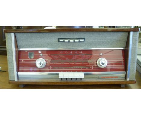 A Cossor, four waveband mains radio, in a teak finished and grey fabric case with press button operation  9.5''h  24''w      