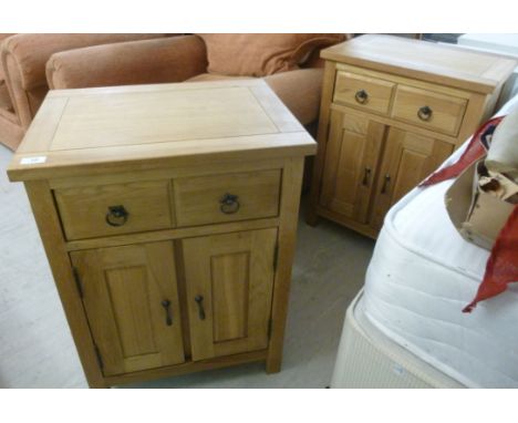 A pair of modern light oak bedside chests, each having a drawer and two panelled doors, raised on block feet  28''h  21''w   
