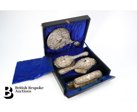 Late Victorian silver plated vanity set, comprising mirror, two hair brushes, clothes brush and damaged comb, housed in a bla