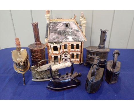 A CERAMIC MODEL OF A VICTORIAN HOUSE with ceramic and metal models of irons and stoves