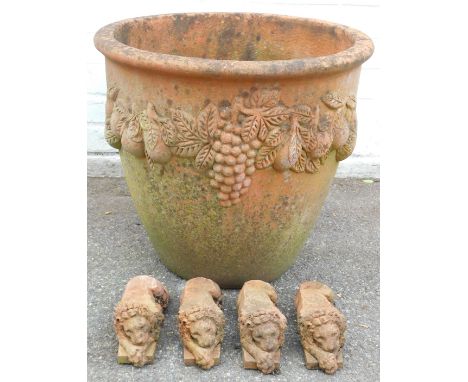 A terracotta planter, with fruit and bloom swags, and four terracotta lion planter raisers, 46cm high, 52cm wide. (5)