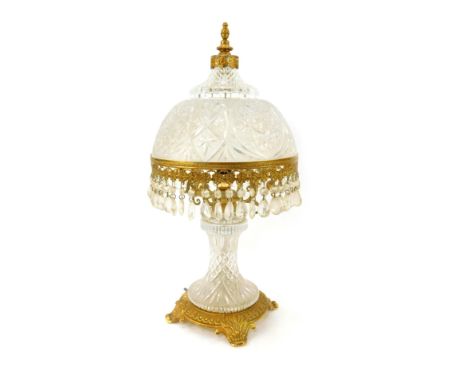 A 20thC cut glass and gilt metal mounted table lamp, the shade with faceted hob nail cut decoration, surrounded by various dr