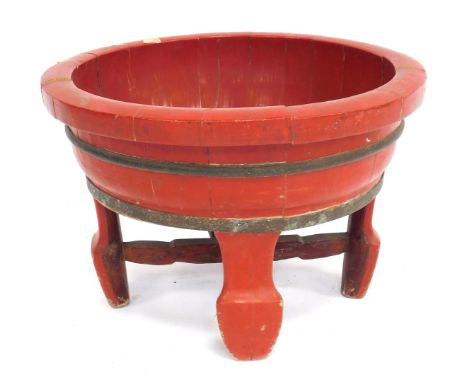 A Chinese red painted planter, with metal banding, 34cm high, 54cm wide. (AF)