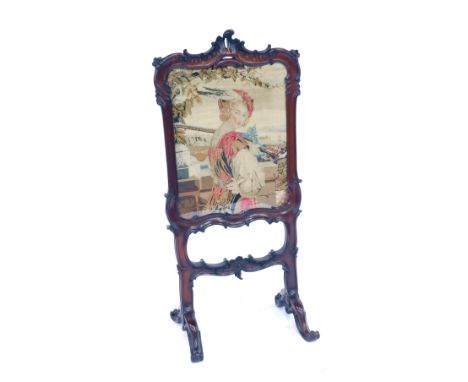 A 19thC rosewood fire screen, the surround carved with scrolls, foliate motifs, etc, on scroll legs, with a central tapestry 