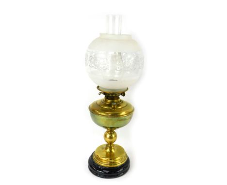A late 19th/early 20thC brass oil lamp, with a clear and frosted glass shade, brass central reservoir, on a circular stepped 