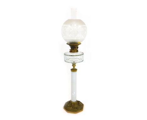 A late 19th/early 20thC oil lamp, with a frosted and clear glass shade, clear glass central reservoir, on a white milk glass 