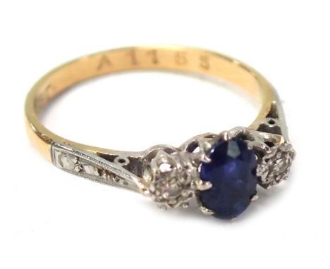 An 18ct gold sapphire and diamond dress ring, the central oval sapphire in claw setting, flanked by two tiny illusion set dia