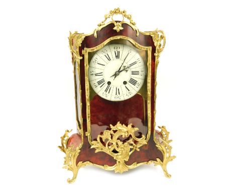 A French tortoiseshell and gilt brass mounted bracket clock, with a Roman numeric and canted white enamel dial, with concave 