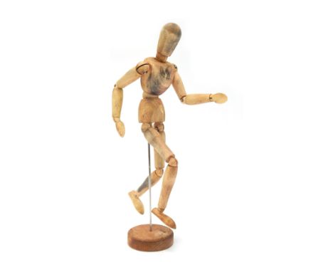 An articulated artist's mannequin, on circular base, 33cm high. 