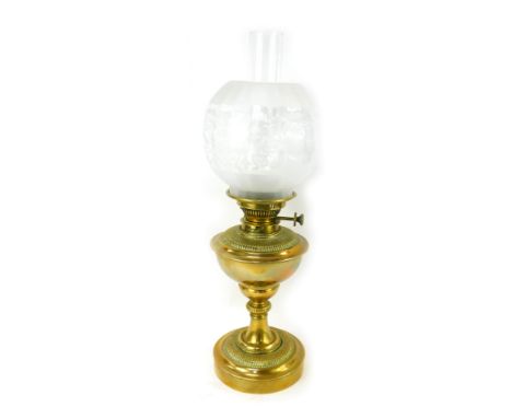 A late 19th/early 20thC brass oil lamp, with a frosted and clear glass shade, brass central reservoir, a moulded column, on a