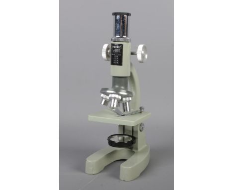 A vintage Prinz Optics Model 100 microscope in wooden storage box.