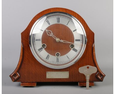 A dome top Smiths Enfield mantle clock, with Roman Numeral dial and bearing presentation plaque to front to 'Joseph Graham up