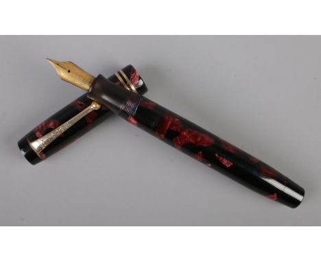 A Parker Duofold fountain pen with red marbled barrel and cap and an 18ct gold nib.